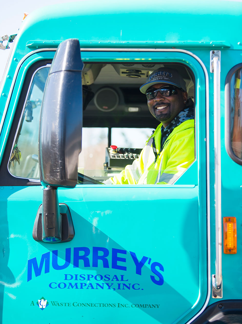 Murry's Disposal driver in truck cab.